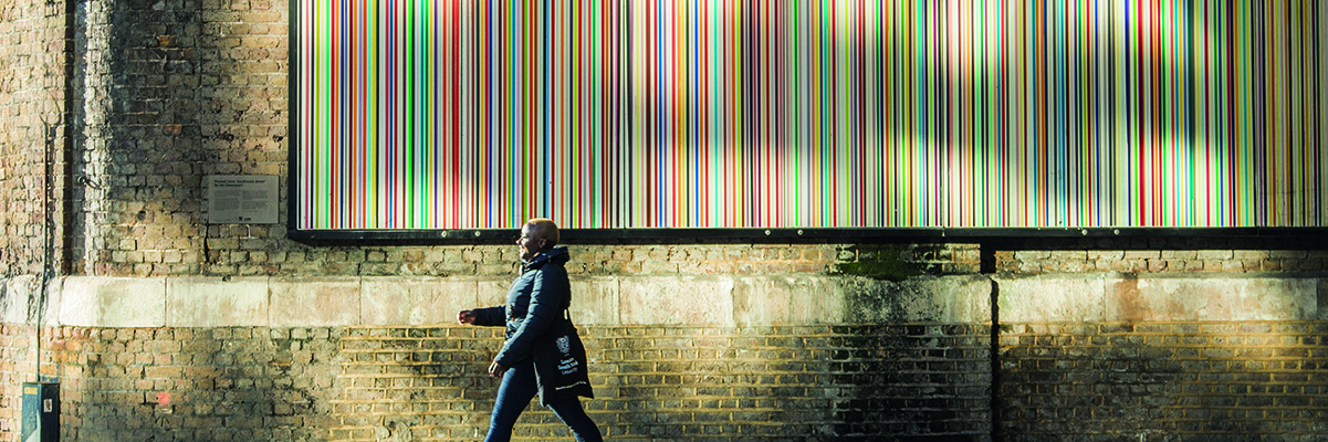 A smiling woman walks confidently down a road